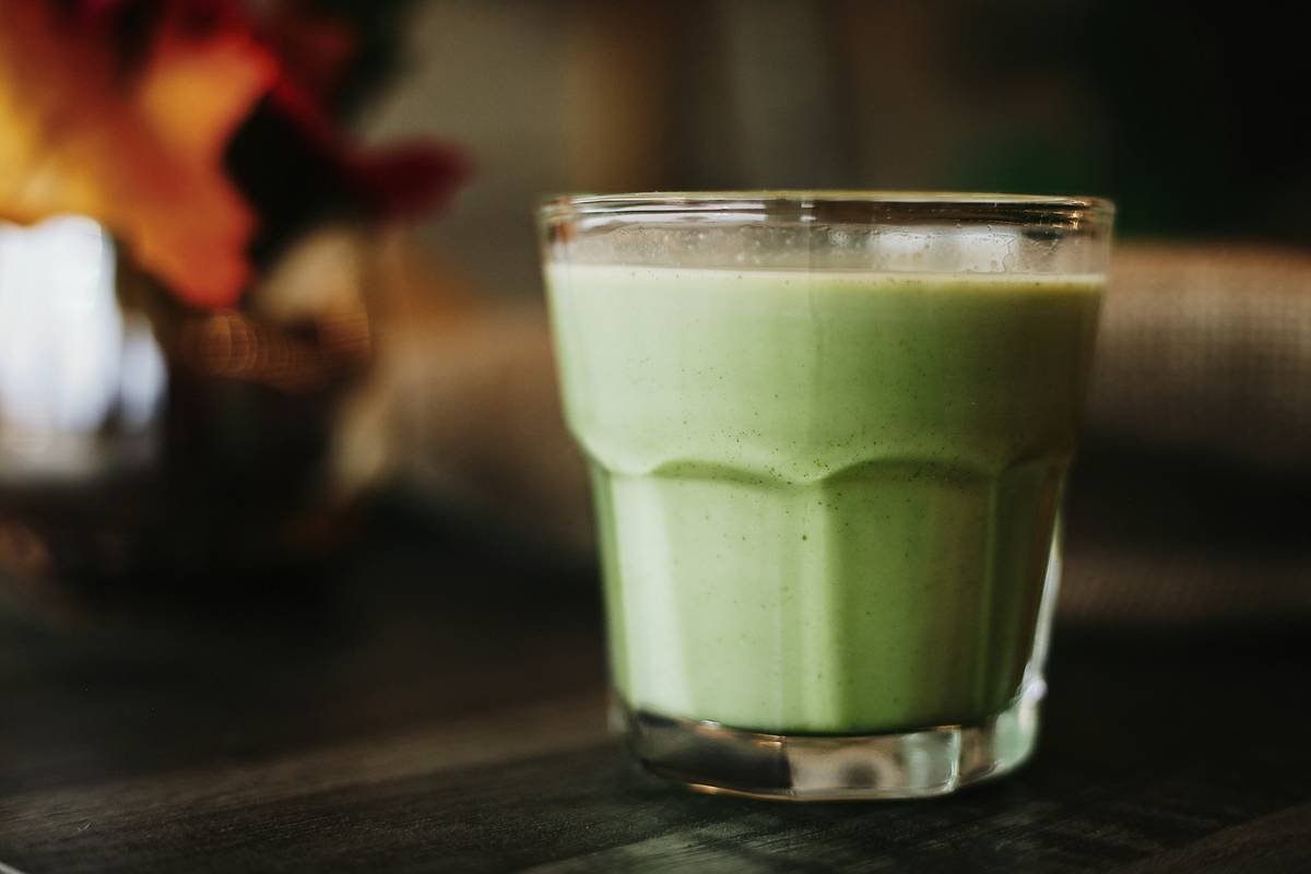 Infographic comparing problematic vs. skin-friendly natural green smoothie ingredients, showing oxalate levels, glycemic impact, and nutrient bioavailability.