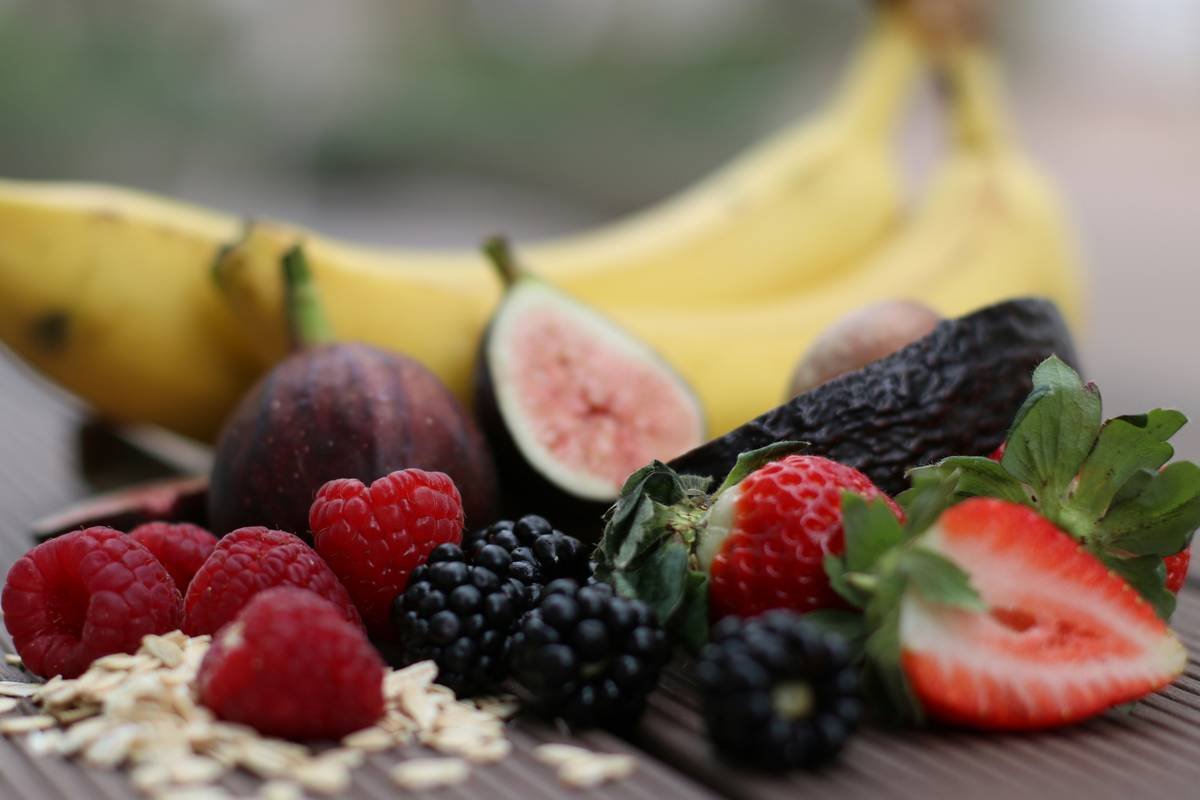 Fresh organic smoothie ingredient selection at farmers market showing vibrant fruits and leafy greens