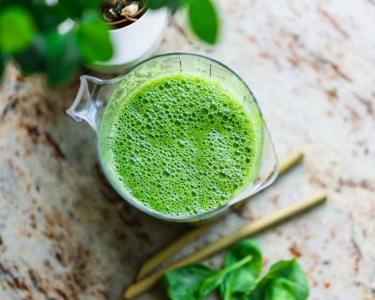 Homemade natural veggie smoothie booster with avocado and fermented greens in blender